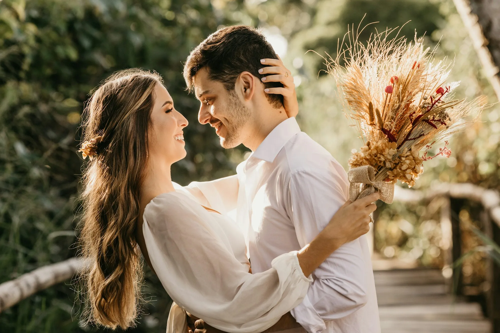 An engaged couple embracing in warm afternoon light