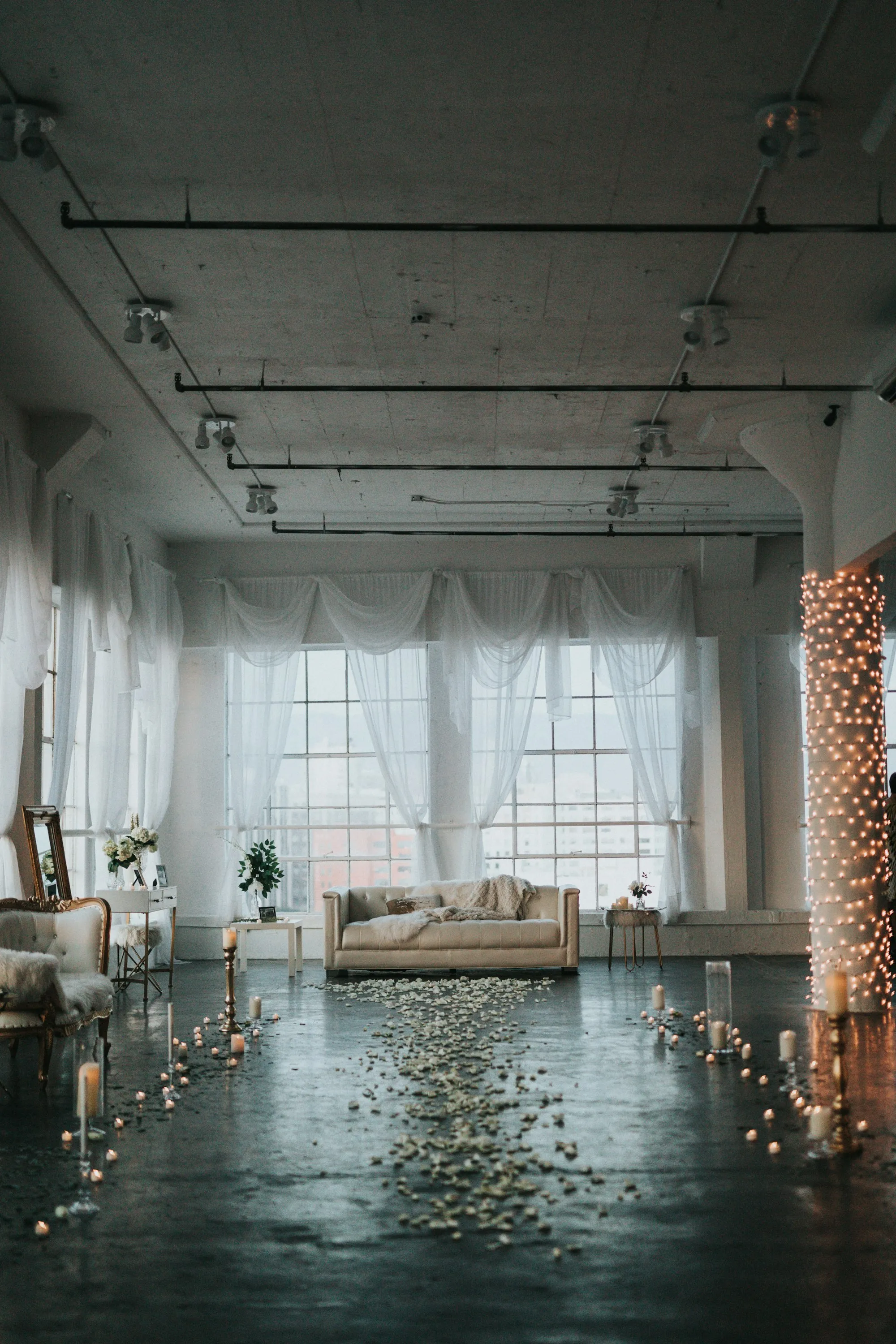 A loft venue glowing with string lights and candles